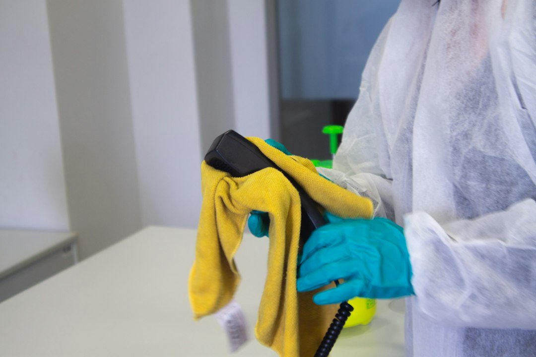 Désinfection d'un poste de travail par un agent en tenue de protection